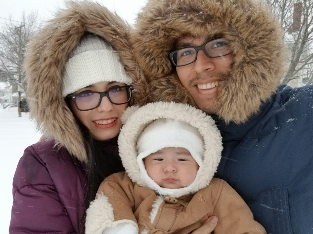 Conrad 30 program recipients Carlos and wife Lupe pose for winter photo with their son 