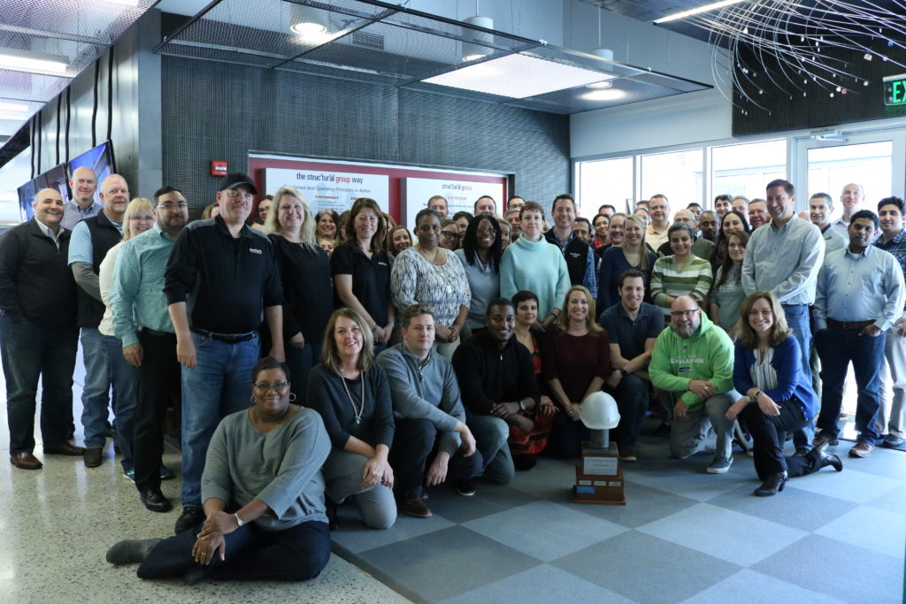 Team members, including staff who are currently being sponsored for U.S. work visas, pose for a picture at Structural Group's corporate headquarters in Columbia, Maryland.
